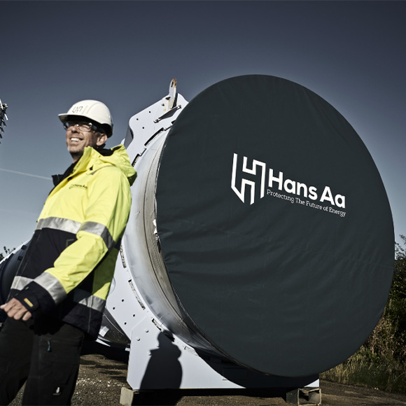 Worker standing in front of a wind turbine tower with a protecting tarp from Hans Aa